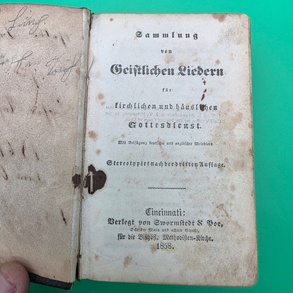antique German-language hymn book titled Sammlung von Geistlichen Liedern, published in 1858 in Cincinnati.