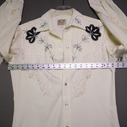 This vintage 1970s H Bar C California Ranchwear "Taos" cream polyester fabric, white fringe detailing, and black and gray floral embroidery with pearl snap