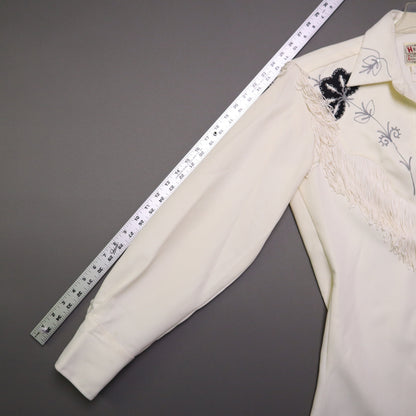 This vintage 1970s H Bar C California Ranchwear "Taos" cream polyester fabric, white fringe detailing, and black and gray floral embroidery with pearl snap