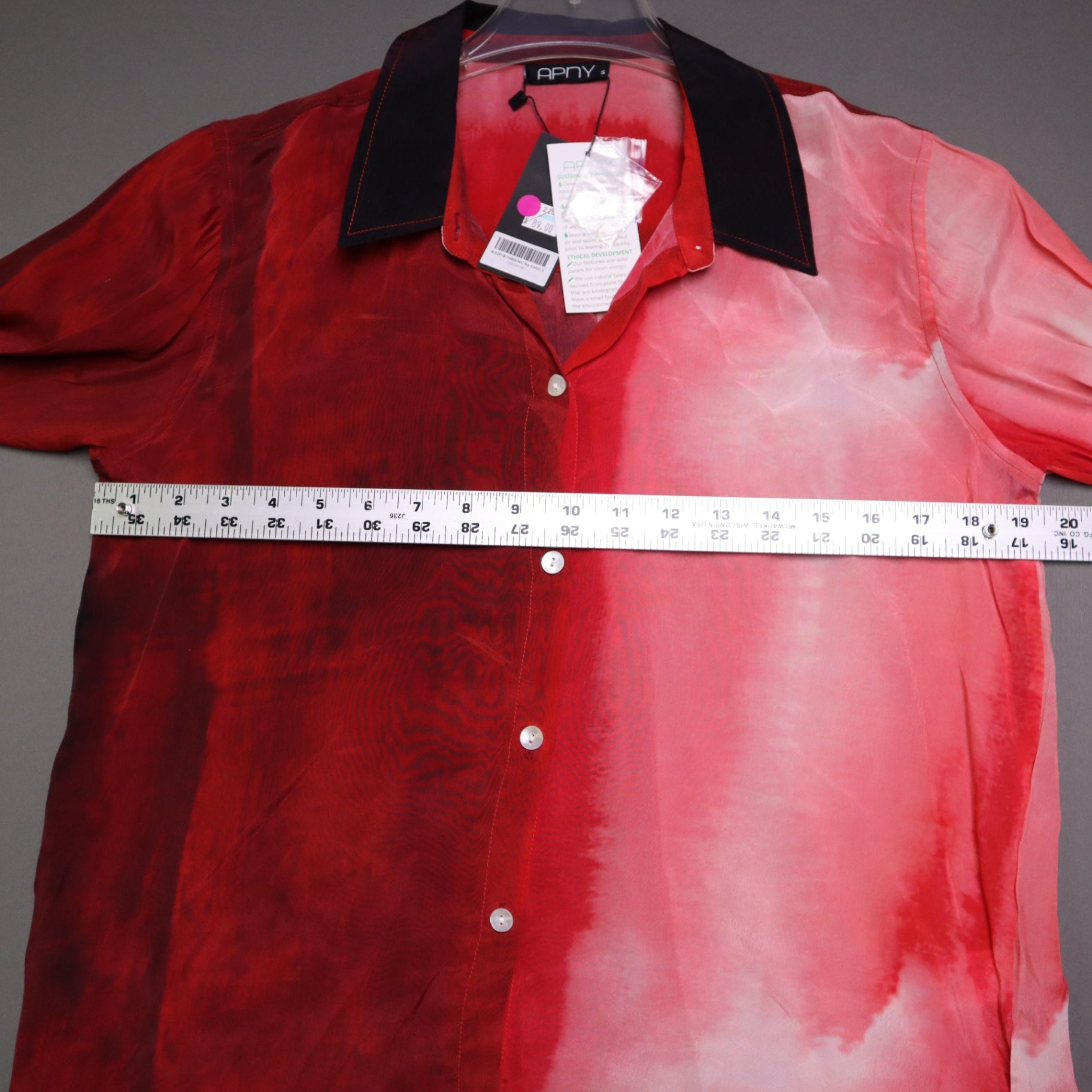 APNY brand button-up shirt features a vibrant red and pink gradient tie-dye pattern and a contrasting dark collar