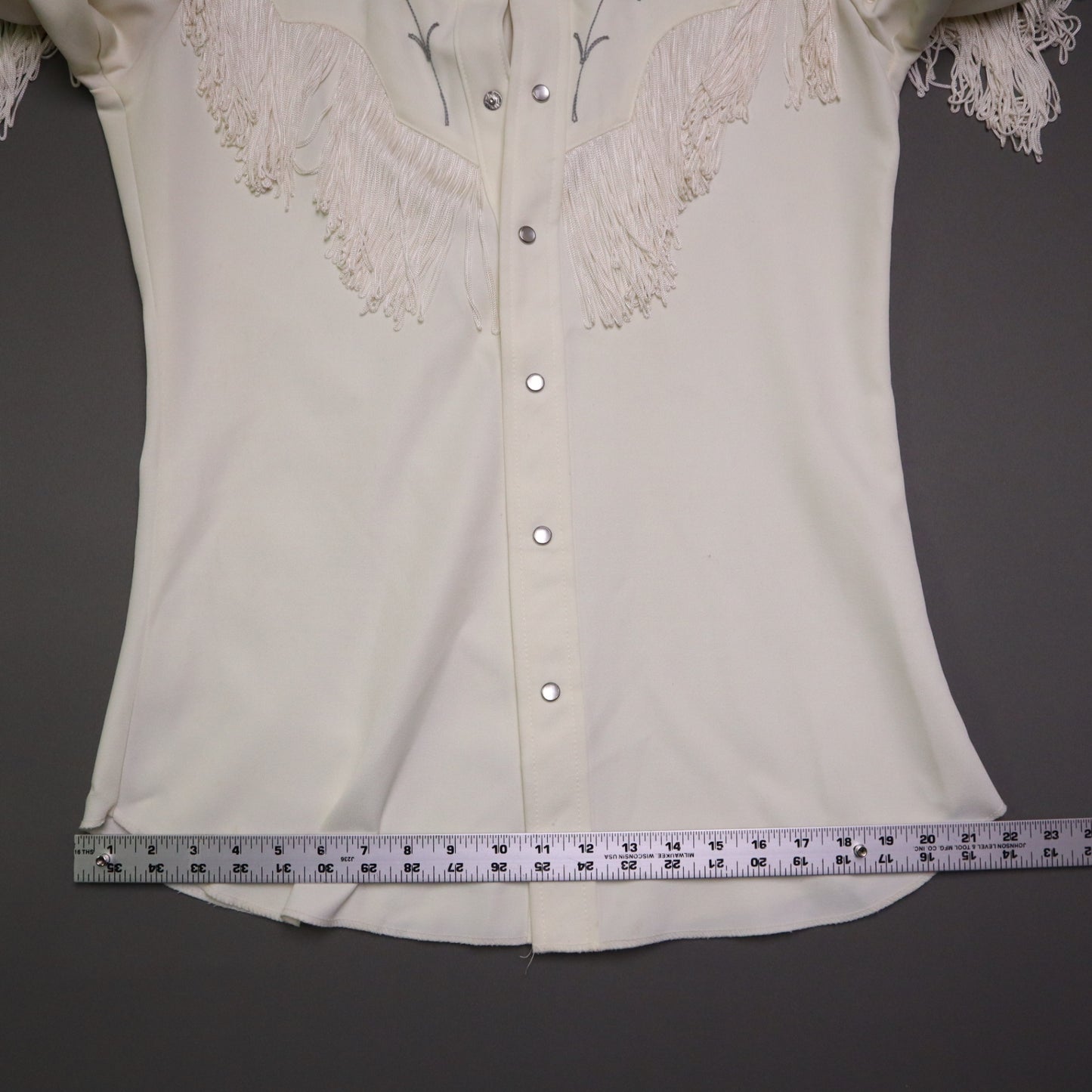 This vintage 1970s H Bar C California Ranchwear "Taos" cream polyester fabric, white fringe detailing, and black and gray floral embroidery with pearl snap