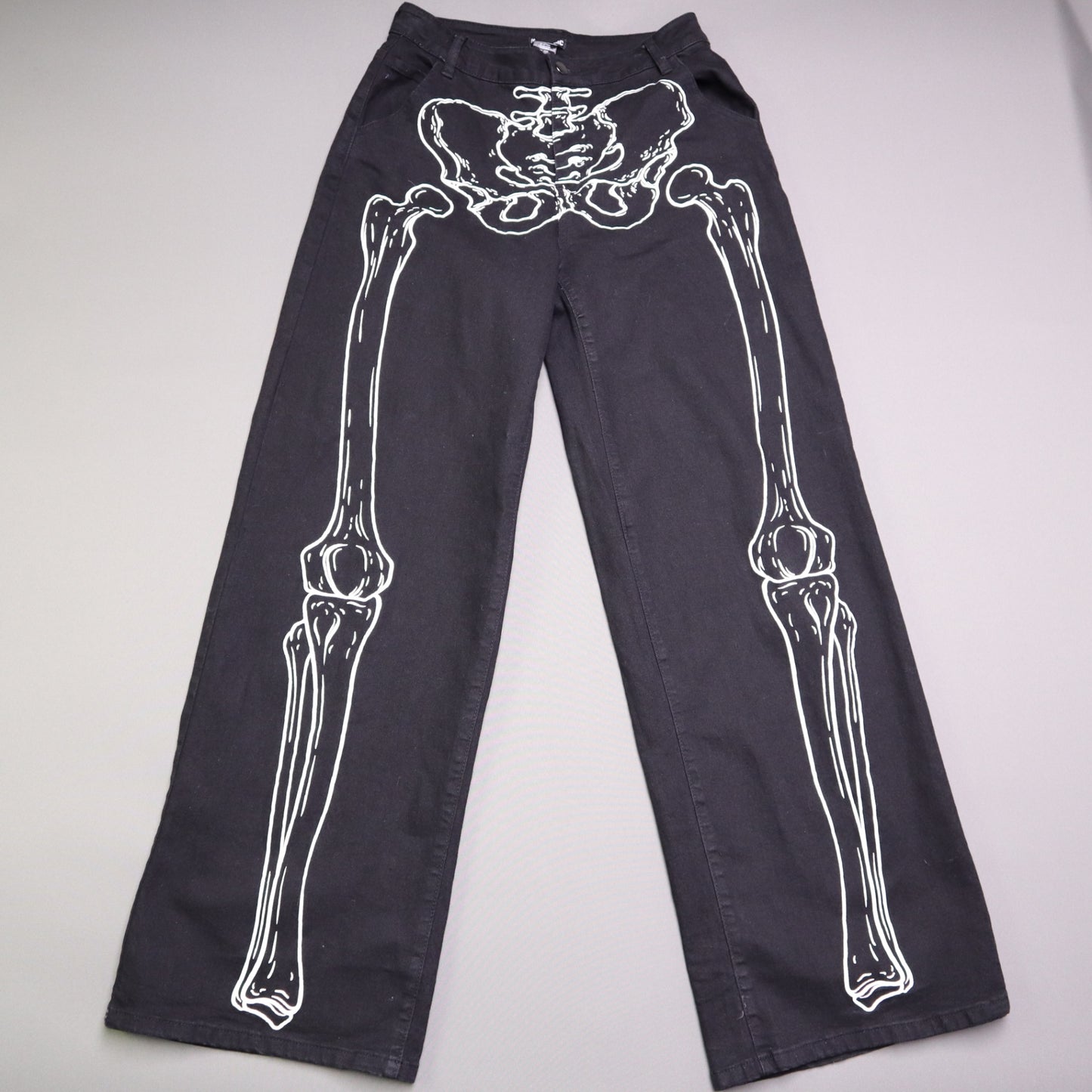 Hot Topic Black Skeleton Outline Wide Leg Pants feature a prominent white pelvic and leg bone print