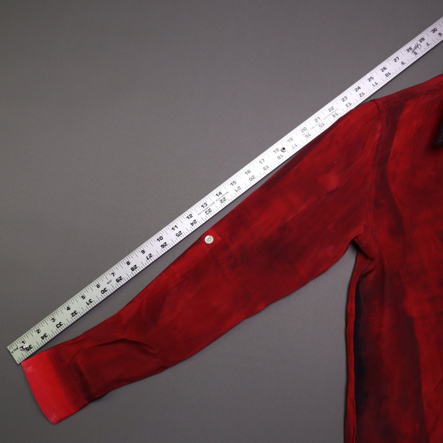 APNY brand button-up shirt features a vibrant red and pink gradient tie-dye pattern and a contrasting dark collar