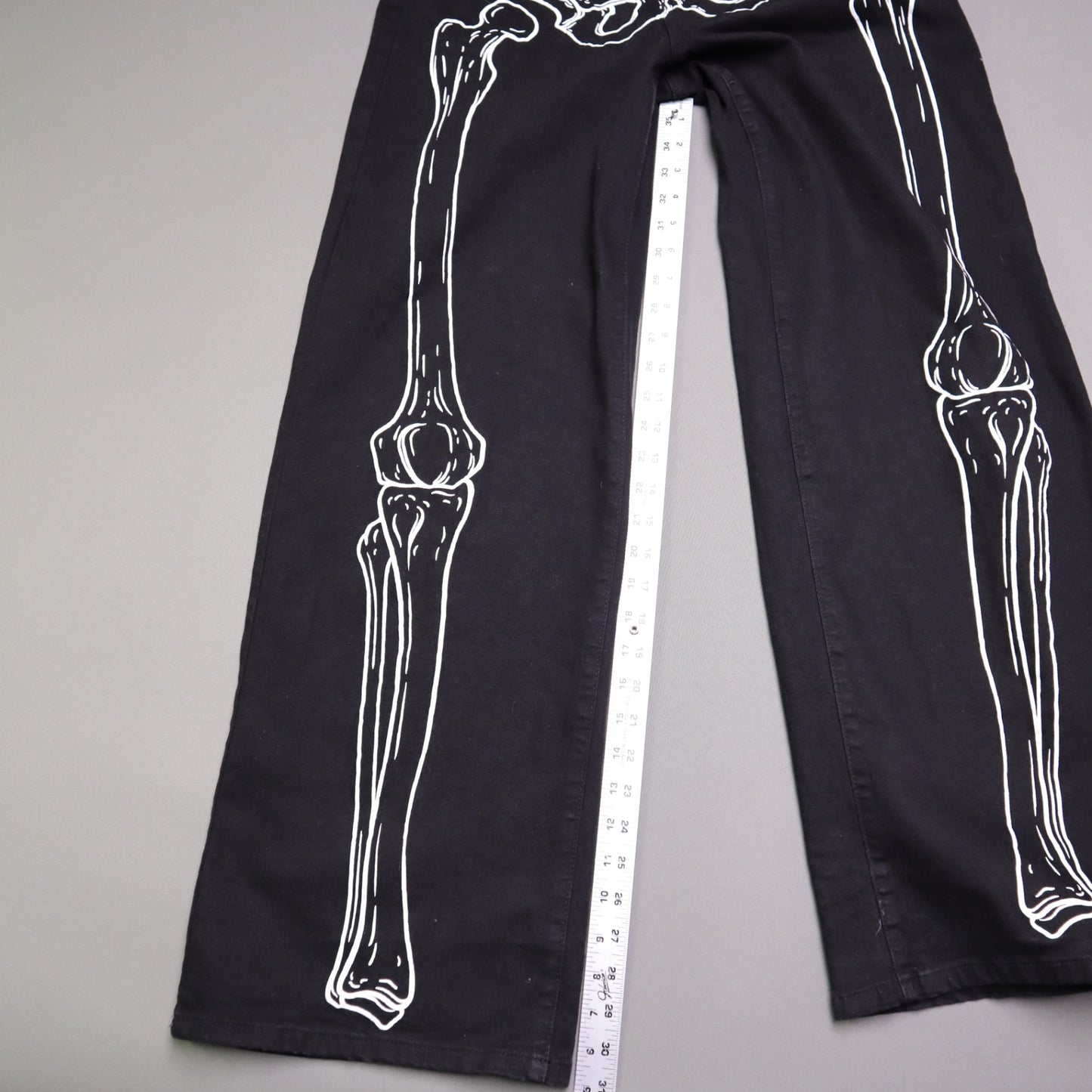 Hot Topic Black Skeleton Outline Wide Leg Pants feature a prominent white pelvic and leg bone print