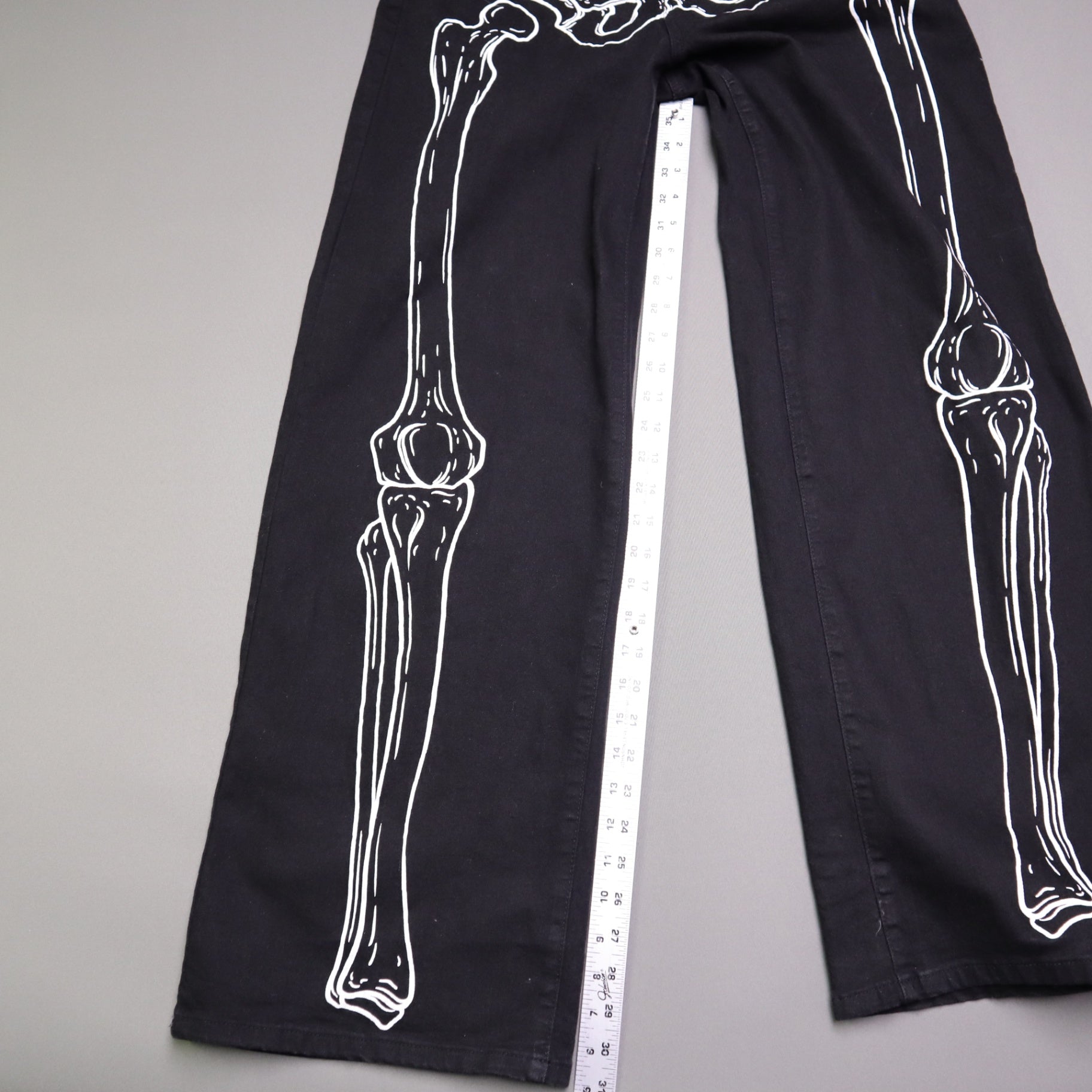 Hot Topic Black Skeleton Outline Wide Leg Pants feature a prominent white pelvic and leg bone print