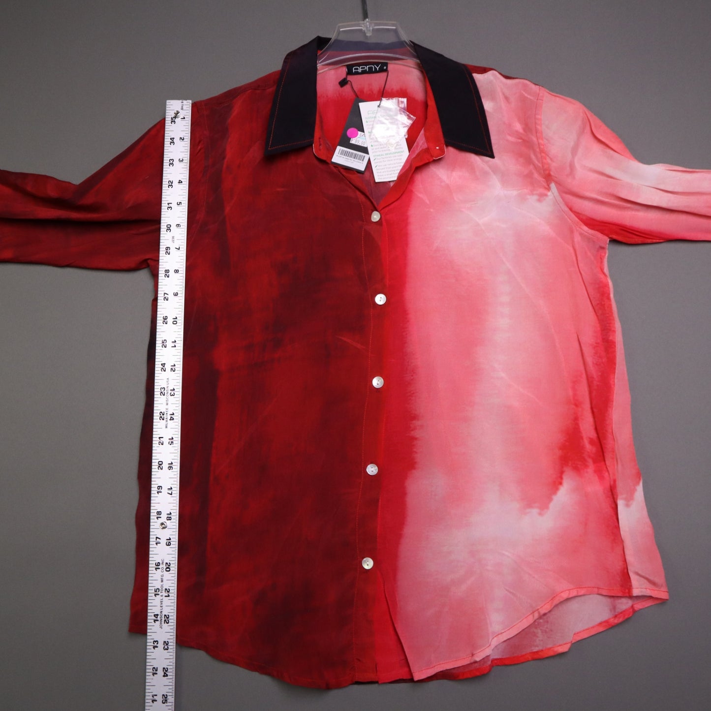 APNY brand button-up shirt features a vibrant red and pink gradient tie-dye pattern and a contrasting dark collar