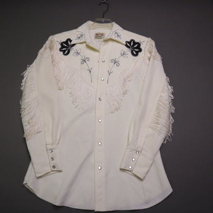 This vintage 1970s H Bar C California Ranchwear "Taos" cream polyester fabric, white fringe detailing, and black and gray floral embroidery with pearl snap